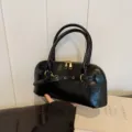 Schwarze Lackleder Handtasche mit zwei Griffen und goldenem Metall Schnallenakzent. - Schwarz