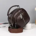Detailansicht der dunkelbraunen, mehrlagigen Kunstleder-Umhängetasche mit Reißverschluss. - Kaffee