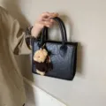 Schwarze strukturierte Handtasche mit niedlichem Plüschbärchenanhänger minimalistische Damentasche - Schwarz Mit Anhänger