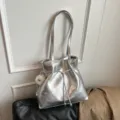 Silberne metallic Schultertasche für Damen, modisches Kordelzug Design mit Plüsch Anhänger. - Mit Anhänger / Silber