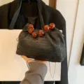 Schwarze Stroh geflochtene Umhängetasche mit stilvollem Bernsteinfarbenem Perlen-Griff chic. - Schwarz