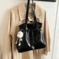 Schwarze glänzende Lackleder-Umhängetasche mit süßem flauschigen Plüsch-Schlüsselanhänger. - Ohne Anhänger / Schwarz