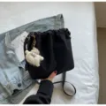 Schwarze Nylon Eimer Tasche Damen Umhängetasche mit flauschigem Anhänger im Alltag. - Schwarz