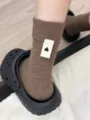 Vista dettagliata di calzini slouch in maglia a costine marroni con etichetta a cuore. - Taglia unica / Marrone