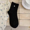 Calze nere da donna a metà tubo con motivi floreali goffrati e grazioso ciondolo ad orsetto. - Taglia unica / Nero