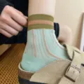 Primo piano dettagliato di calze a metà polpaccio in rete traspirante con righe verticali. - Verde Chiaro