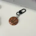 Detailed view of creative basketball keychain, resin pendant with black metal clasp for bags. - Basketball