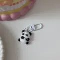 Cute panda keychain detail, cartoon animal pendant with white clasp, close-up view. - Panda
