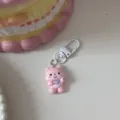 Cute pink cartoon animal keychain detail shot, premium resin pendant with durable white clasp. - Dog