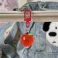 Primo piano dettagliato di un simpatico portachiavi a mela rossa trasparente 3D. - Mela Rossa