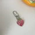 Clear glitter gradient strawberry keychain detail view showing cute bag charm accessory. - Red