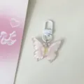 Close-up detail view of the translucent pink floral resin butterfly keychain pendant charm. - Light Pink