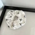 White lace bow scrunchie detail view, elegant hair accessory for women daily styling and fashion wear. - White