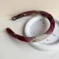 Rotes Wollhaarband Produktdetail Nahaufnahme mit weichem Textilstoff und goldenem Metalldetail. - Grau-Rot Kariertes Haarband