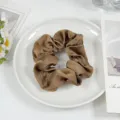 Brown satin hair scrunchie detail view, elegant hair tie accessory showcasing soft fabric. - Coffee