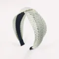 Cerchietto intrecciato in rafia con un design incrociato chic e comoda fodera nera. - Bianco