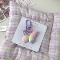 Detailed close-up shot of the colorful gradient butterfly keychain charm with purple clasp on card. - Purple