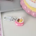 Close-up detail shot of a cute pink heart cake keychain charm accessory with metal clasp. - Rose Red