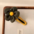 Pinza de pelo de lana con flor, pétalos verde oscuro, centro amarillo, accesorio elegante. - Verde