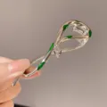 Silver snake hair claw clip with green enamel details and sparkling red eyes for elegant styling. - Green Snake Silver