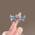 Blue butterfly waist tightening buckle detail shot, metal jeans waist adjuster clip for loose pants. - Blue