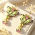 Exquisite vintage enamel moth dangle earrings detail close-up showcasing pink gemstone accent. - Green