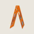 Gedetailleerd overzicht van een oranje zijden twilly sjaal met leuke motieven voor tassen. - Tas Inception Stijl 1