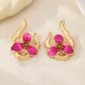 Close-up detail shot of irregular gold and pink enamel flower stud earrings, chic. - Rose Red