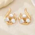 Close-up of gold irregular flower earrings with white enamel petals and elegant abstract curved metal lines. - Off White