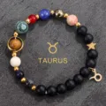 Close-up detail of the natural stone solar system bracelet featuring a gold Taurus zodiac charm. - Taurus