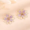 Close-up detail of the purple enamel hollow double-layer flower earrings, shiny gold finish. - Light Purple