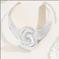Detailed close-up of a silver tone geometric statement choker necklace with a bold spiral design. - Silver Gray