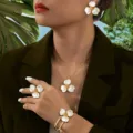Vista dettagliata dell'elegante set di gioielli floreali con collana, orecchini e bracciale. - Bianco