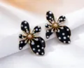 Detailed close-up of stylish black white polka dot flower earrings with gold tone for summer. - Black White Polka Dot