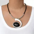 Close-up detail of bohemian spiral pendant necklace with black gemstone and silver metal. - Single Spiral Silver Gray Necklace