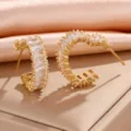 Elegante vergulde C-vormige creolen met sprankelende baguette zirkonia stenen. - 16K goud