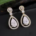 Elegante vergulde druppelvormige zirkonia hangende oorbellen met schitterende pave halo. - Goud