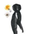 Close-up detailweergave van de elegante zwarte en witte polkadot chiffon sjaal voor stijl. - Stippen