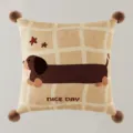 Primo piano dettagliato di un cuscino quadrato con stampa di bassotto e pon-pon morbidi agli angoli. - Stampa Bifacciale 40x40cm (Copertura Senza Imbottitura) / Bassotto Marrone A Quadri