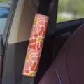 Closeup of a retro floral car seat belt cover installed on a car interior seatbelt strap. - A-33 Floral Seat Belt 04
