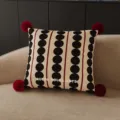 Close-up detail of retro polka dot throw pillow featuring stylish red pom-poms on sofa. - 35x35cm Double-Sided Pattern (Cover Only) / Coffee Polka Dot Beige Red Pom-Pom