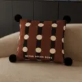 Detailed view of the retro polka dot square throw pillow with black pom-poms on a cozy sofa. - 35x35cm Double-Sided Pattern (Cover Only) / Coffee Polka Dot Brown Black Pom-Pom