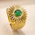 Detailaufnahme des goldenen Vintage-Edelstahlrings mit Sonnenblende und grünem Stein. - Ovaler grüner Stein