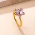Detalle en primer plano de un anillo chic de acero dorado con una circonita rosa en estrella. - Talla 7 / Rosa