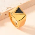Nahaufnahme des goldenen Edelstahlrings mit schwarzem Dreiecksstein und feiner Musterung. - Größe 9 / Gold (Schwarzer Strass)