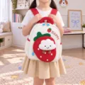 Detailed view of the kids strawberry plush cloud backpack, soft and cute design with side pockets. - White