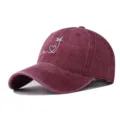 Close-up of the exquisite white wave heart and palm tree embroidery on a burgundy cap. - Adjustable / Burgundy