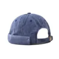 Detailed view of the blue washed denim docker cap, showing rolled cuff and metal buckle strap. - Adjustable / Washed Navy Blue