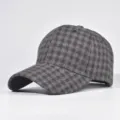 Close-up detail showing the fabric texture and pattern of the classic plaid wool cap. - Adjustable / 06