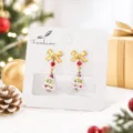 Gros plan détaillé de boucles d'oreilles sapin de Noël en verre avec nœud élégant pour un look festif. - Sapin de Noël en Verre Style 1